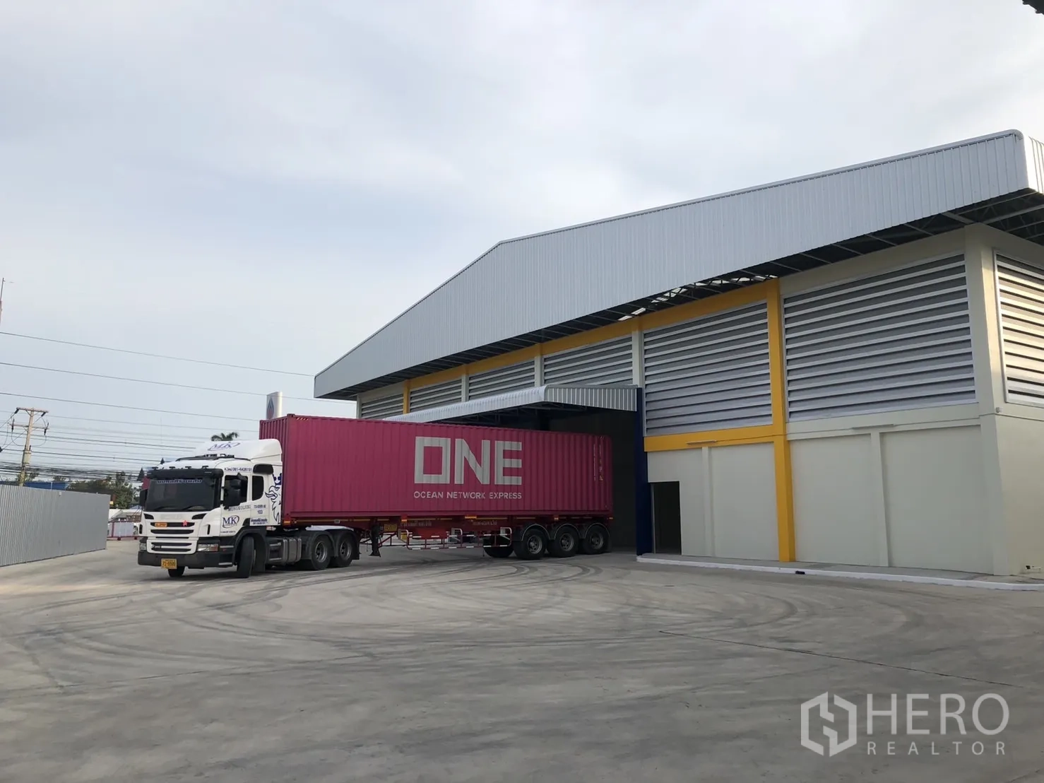 Factory for rent in Mueang Samut Sakhon, Samut Sakhon - Container truck accessing the warehouse under a covered loading bay, showing wide turning space for trailers.