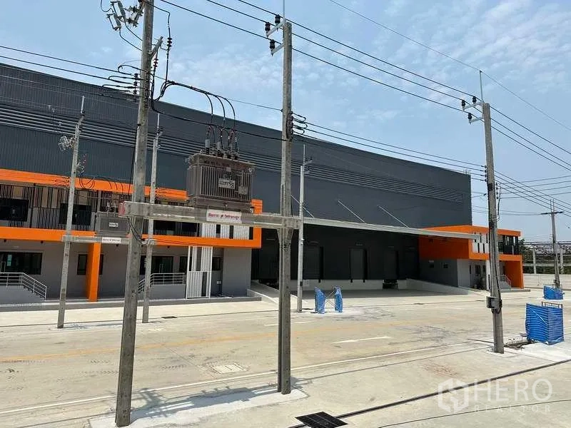 Factory for rent in Bang Phli, Samut Prakan - Front apron with power infrastructure and transformer facing the warehouse loading docks.