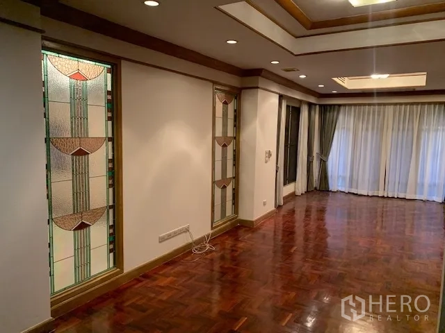 Detached House for rent in Khan Na Yao, Bangkok - Hallway with decorative stained-glass panels, recessed tray ceiling, and full-length curtains.