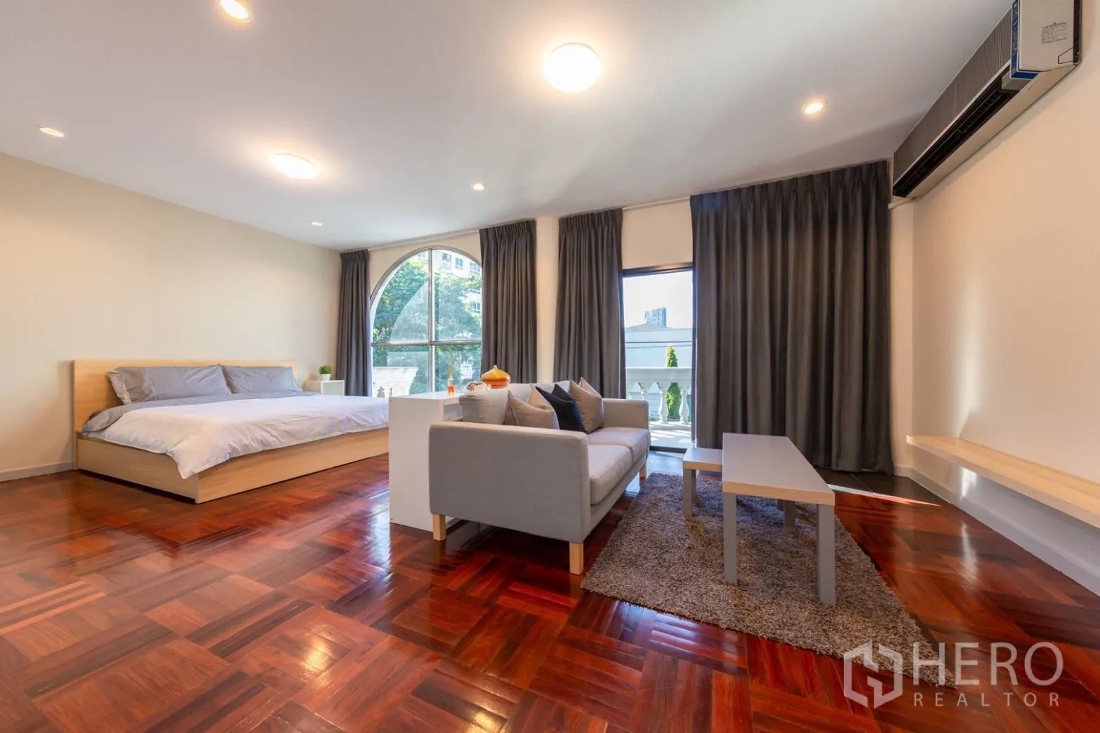 Home Office for rent in Bang Rak, Bangkok - Spacious master suite with parquet wood floors, sofa corner and an arched window.