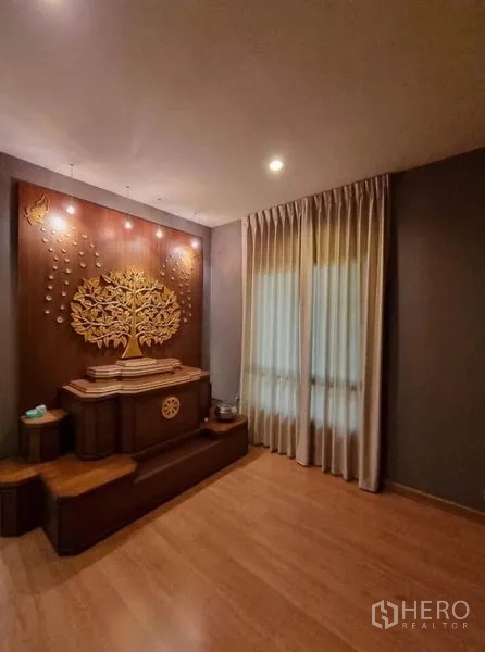 Detached House for sale in Suan Luang, Bangkok - Warm multipurpose room with wood flooring, curtains and a decorative feature wall.