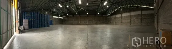 Warehouse for rent in Mueang Pathum Thani, Pathum Thani - Panoramic view of empty warehouse floor showing column-free layout, overhead lighting and side loading access.
