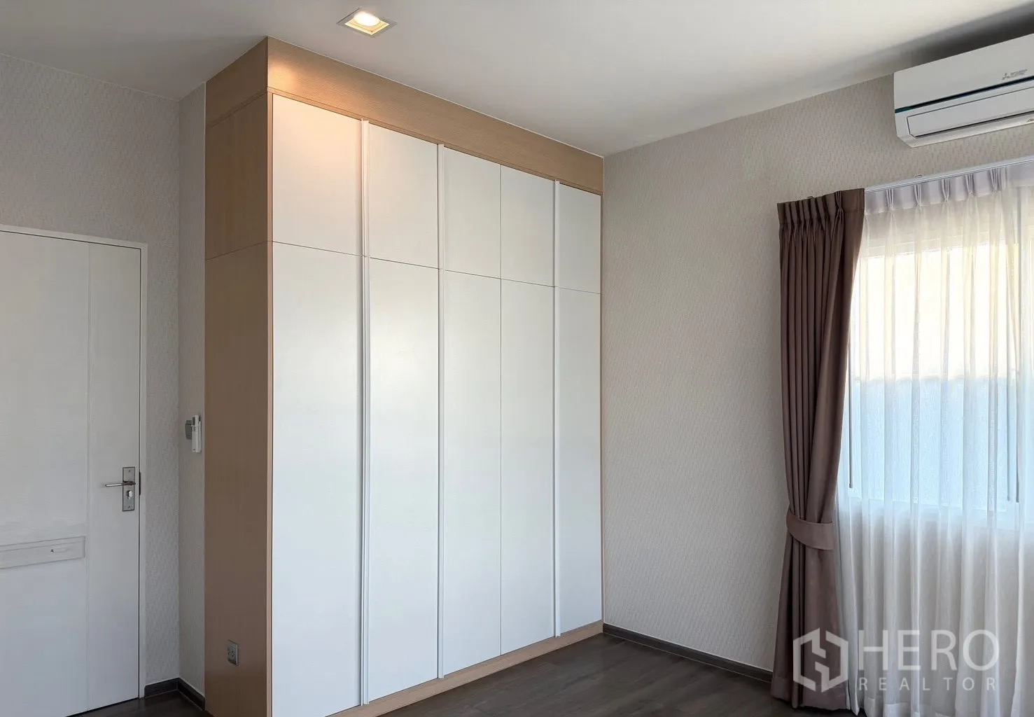 Detached House for rent in Prawet, Bangkok - Bedroom with two curtained windows and hardwood floor