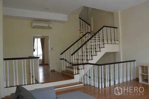 Home Office for rent in Wang Thonglang, Bangkok - Split-level staircase with white balustrades connecting open-plan floors in a Bangkok home office.