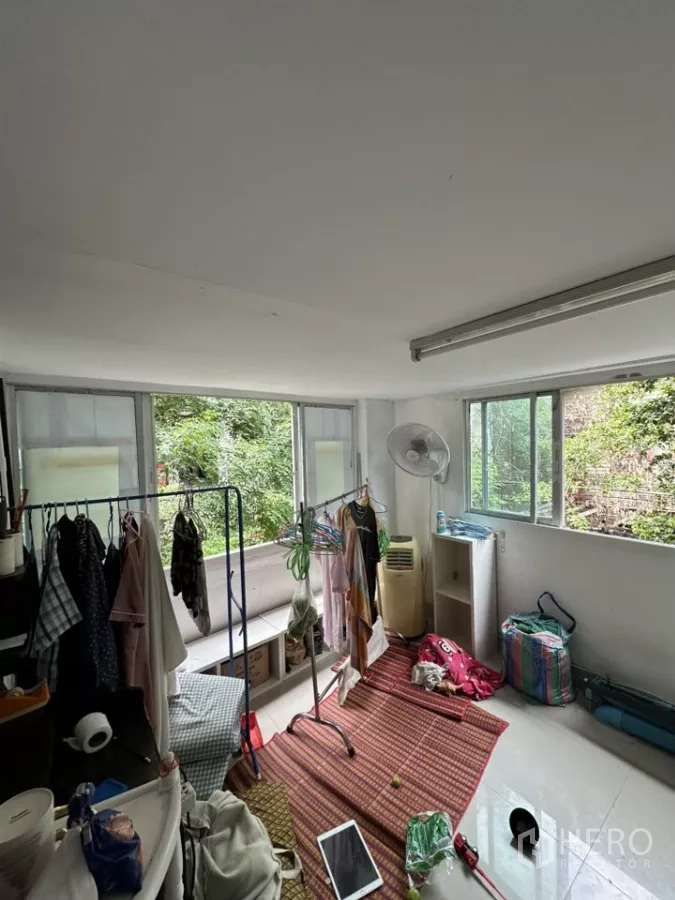 Retail Space for rent - Bright multipurpose room with sliding windows, clothes racks and green views outside.