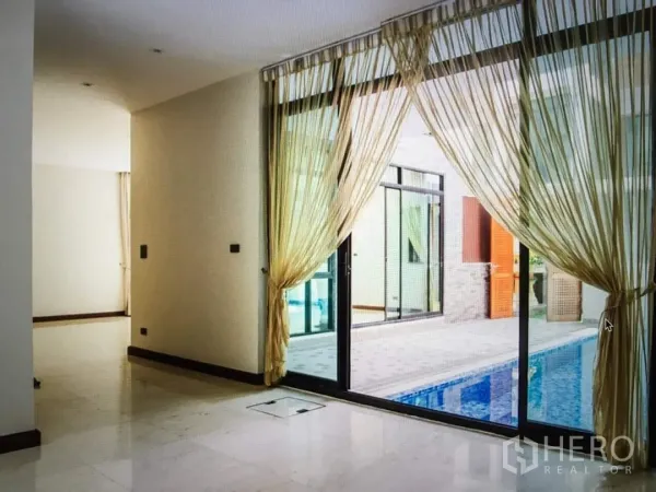 独立式住宅 出租在Khlong Toei, Bangkok - 采光充足的起居区，推拉落地门与薄纱窗帘通向泳池。