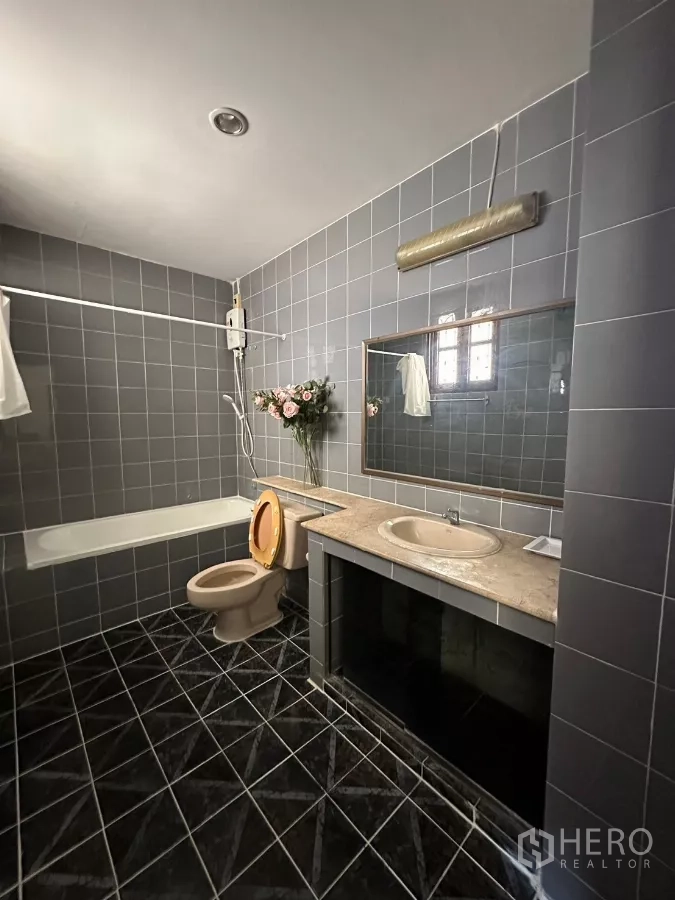 Home Office for rent in Suan Luang, Bangkok - Gray tiled bathroom with bathtub, vanity, and shower.