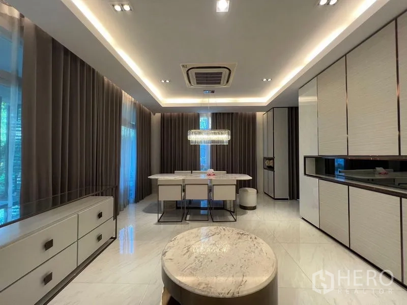 Detached House for sale - Dining zone with crystal chandelier, floor-to-ceiling drapes and views toward the kitchen.