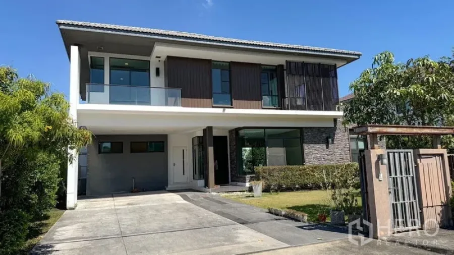 Detached House for sale in Bang Kapi, Bangkok - Two-storey detached house exterior with driveway parking, balcony, and gated entrance.