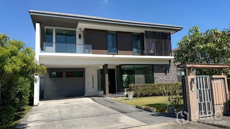 Detached House for sale in Bang Kapi, Bangkok - Two-storey detached house exterior with driveway parking, balcony, and gated entrance.