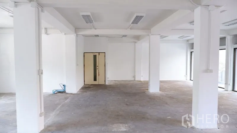 Office Space for rent in Watthana, Bangkok - Central view of an open office floor with structural columns and ample daylight.