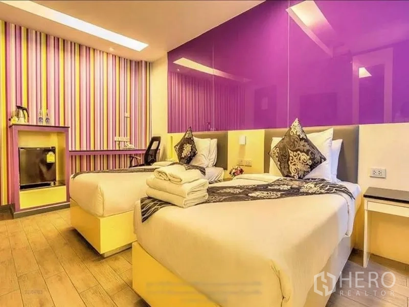 Shophouse for rent or sale in Khlong Toei, Bangkok - Twin bedroom with a purple feature wall, striped wallpaper, and a work desk.