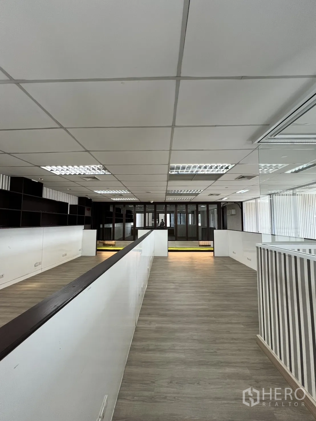 Office Space for rent in Watthana, Bangkok - Central aisle in an open-plan zone with white partitions and wood floors.