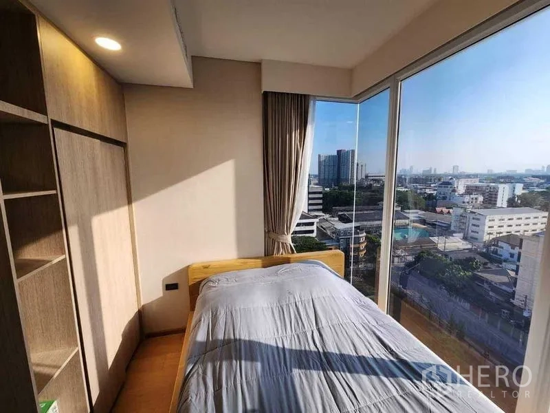 Condominium for rent in Khlong Toei, Bangkok - Corner bedroom with wraparound glass and expansive Bangkok views.