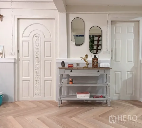 Detached House for rent in Huai Khwang, Bangkok - Entry hall with decorative doors, mirrors and a console table on wooden flooring.