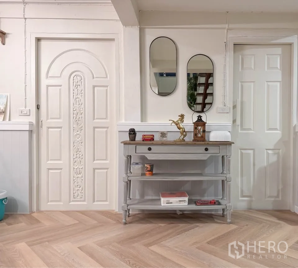 Detached House for rent in Huai Khwang, Bangkok - Entry hall with decorative doors, mirrors and a console table on wooden flooring.
