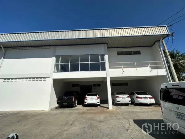 Factory for rent in Si Racha, Chon Buri - Front facade of the factory showing covered parking bays and a glass-fronted mezzanine office.
