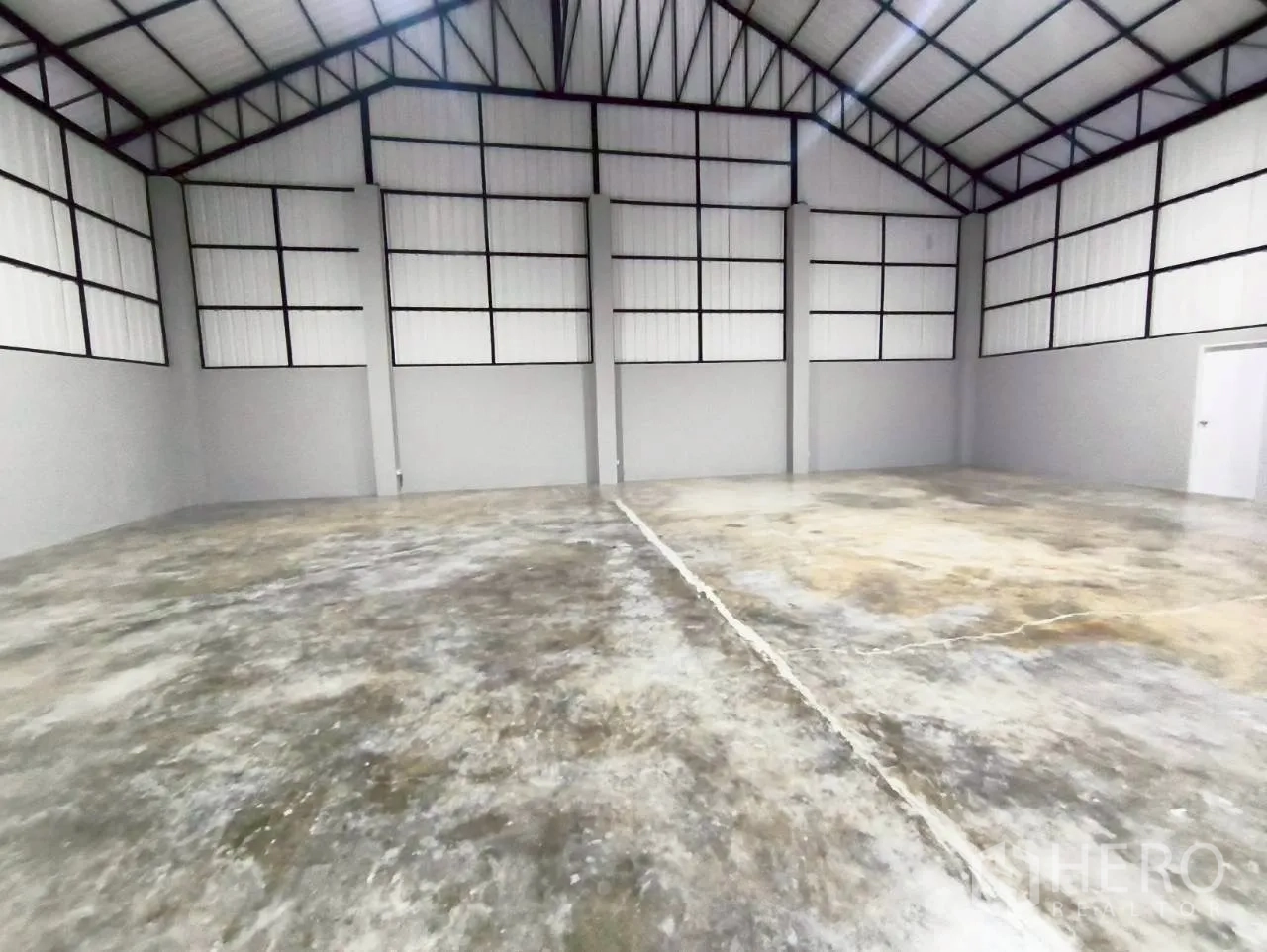 Warehouse for rent in Mueang Nonthaburi, Nonthaburi - Large warehouse hall with high ceiling, steel trusses, and concrete floor.
