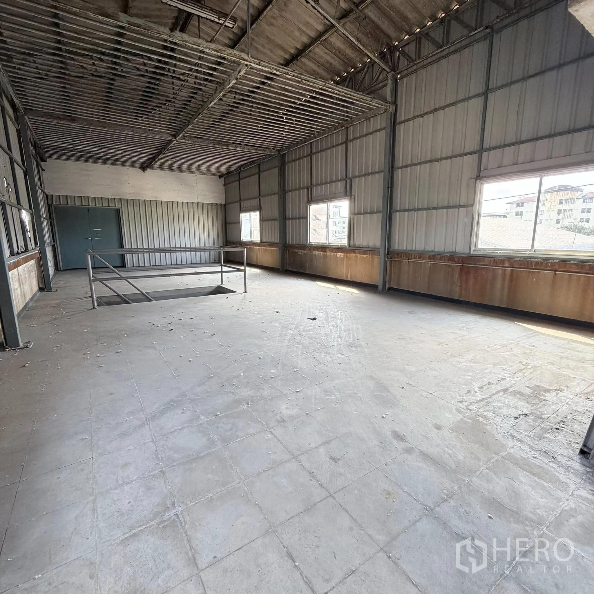 Factory for rent in Phra Pradaeng, Samut Prakan - Upper-level industrial room with windows and a tiled floor inside the factory.