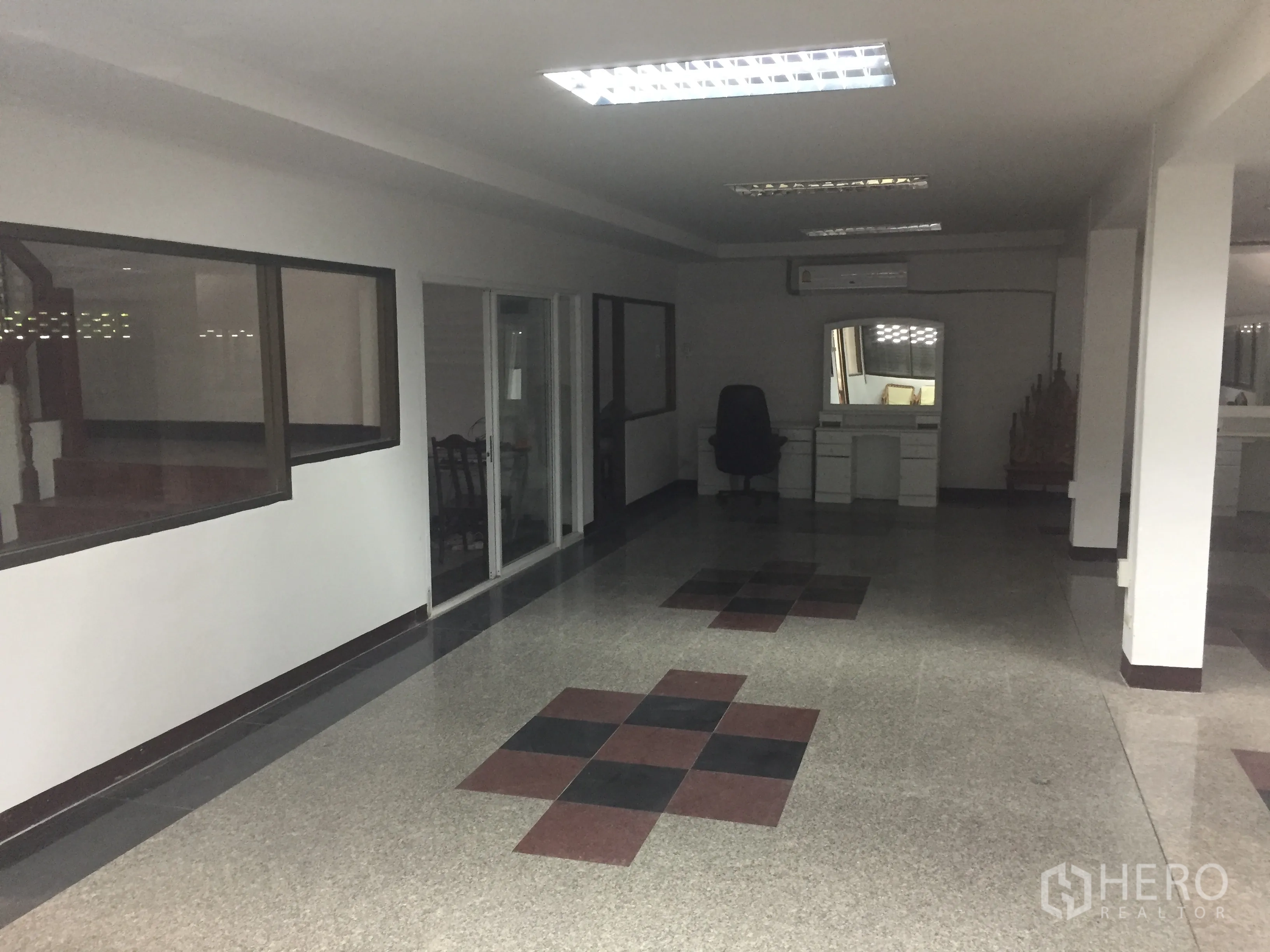 Home Office for rent in Watthana, Bangkok - Open-plan home office level with terrazzo floors, glass-partitioned rooms and fluorescent ceiling lights.