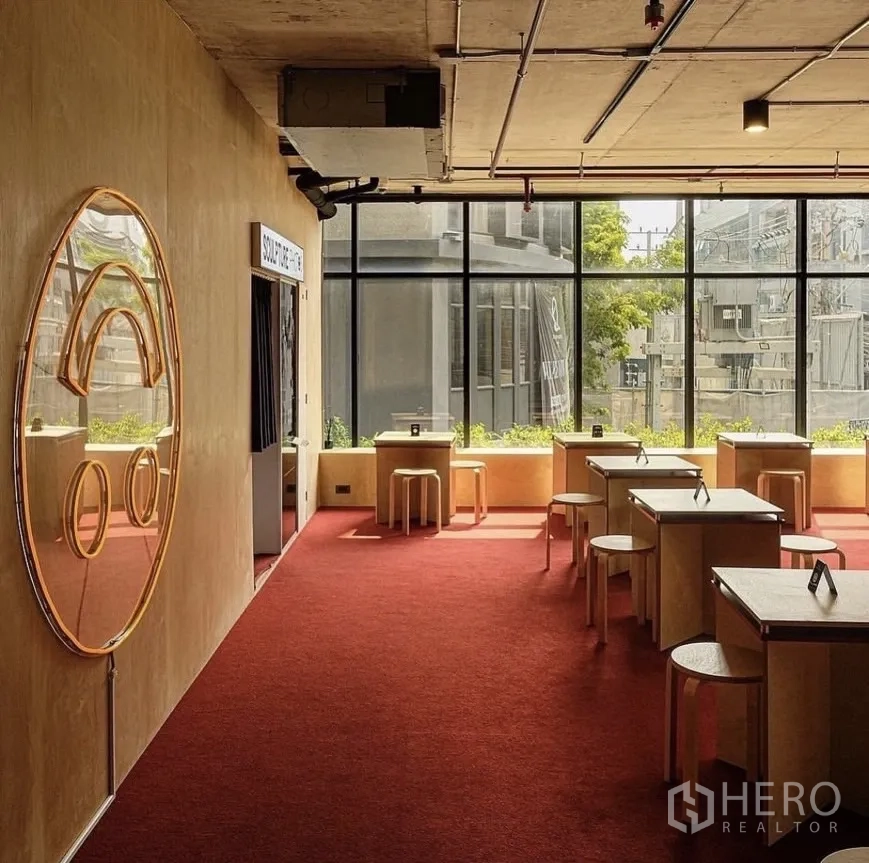 Retail Space for rent in Watthana, Bangkok - Furnished upper level with tables, stools, red carpet and large windows.