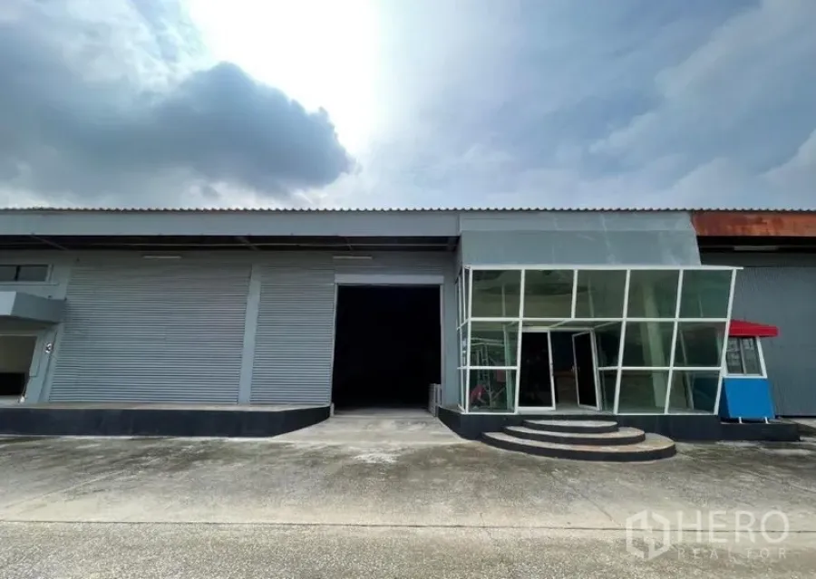 Warehouse for rent in Sam Phran, Nakhon Pathom - Another wide front view of the warehouse facade, driveway, and glass office.