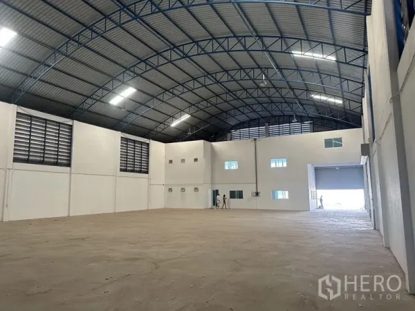 工厂 出租在Bang Bo, Samut Prakan - 开阔仓库地面，拱形钢梁屋顶与墙体百叶通风口。