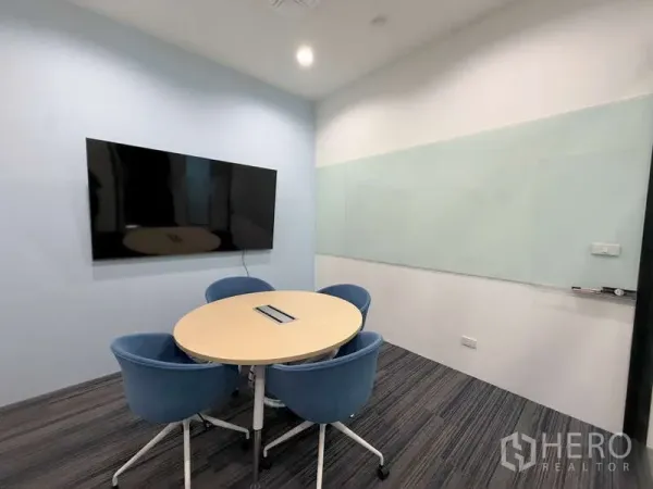 办公空间 出租在Huai Khwang, Bangkok - 小型会议室，圆桌四椅，壁挂屏幕与玻璃白板。