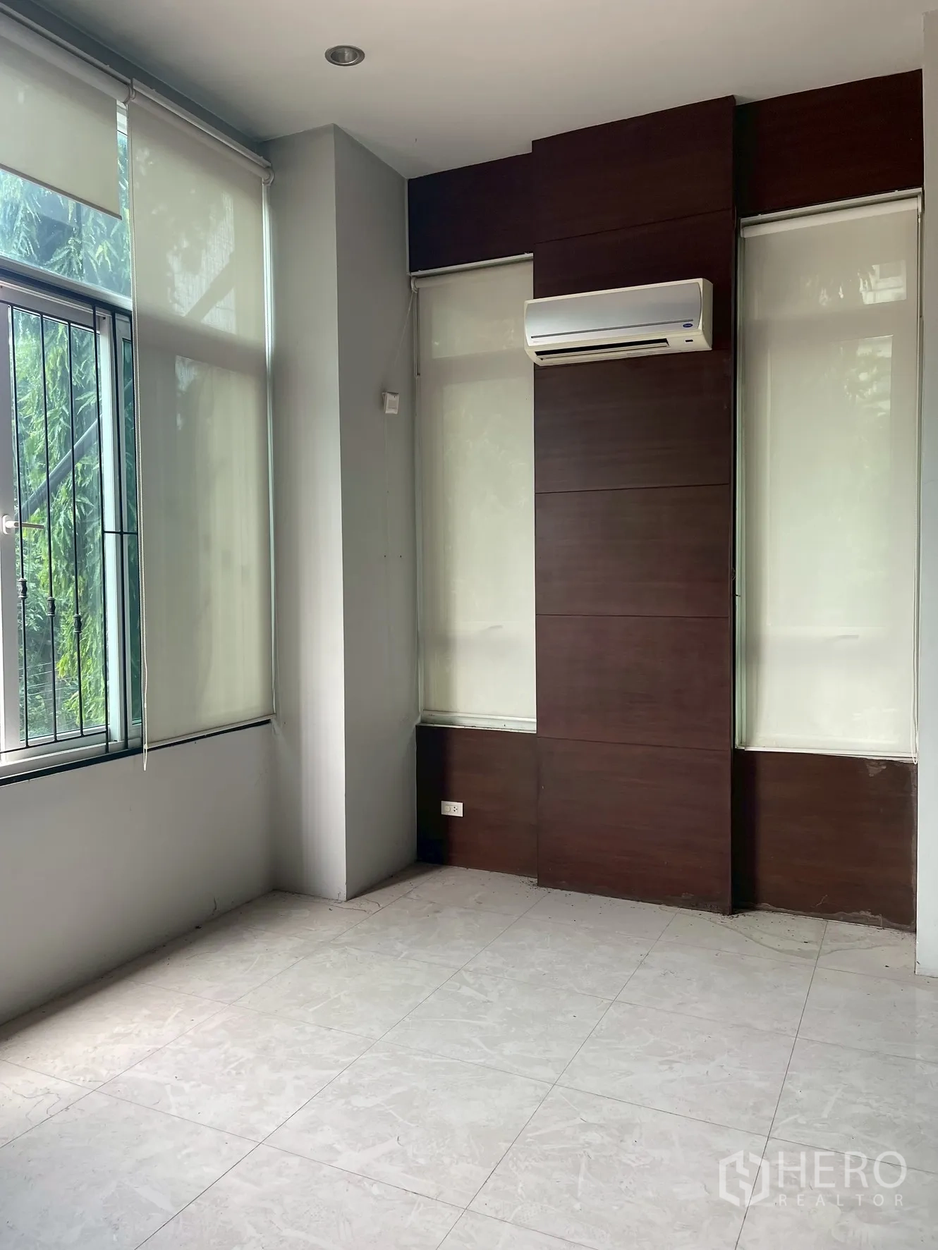 Home Office for rent in Wang Thonglang, Bangkok - Bright office room with large windows, blinds and wall-mounted air conditioner.
