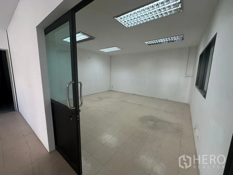 คลังสินค้า ให้เช่าในSaphan Sung, Bangkok - ห้องสำนักงานโล่ง ประตูกระจก พื้นกระเบื้อง และไฟฟลูออเรสเซนต์ในโกดังกรุงเทพฯ