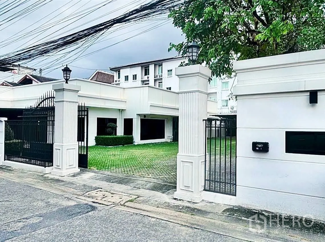 Home Office for rent in Lat Phrao, Bangkok - Gated home office exterior with lawn, driveway and white pillars.