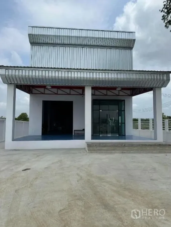 货栈 出售在Khlong Luang, Pathum Thani - 仓库外立面，宽阔车道与金属雨棚屋面。