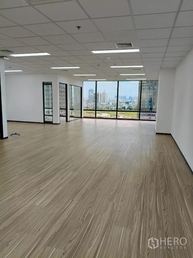办公空间 出租 - 明亮的开放式办公室，木纹地板、格栅吊顶与LED灯，落地窗俯瞰曼谷天际线。