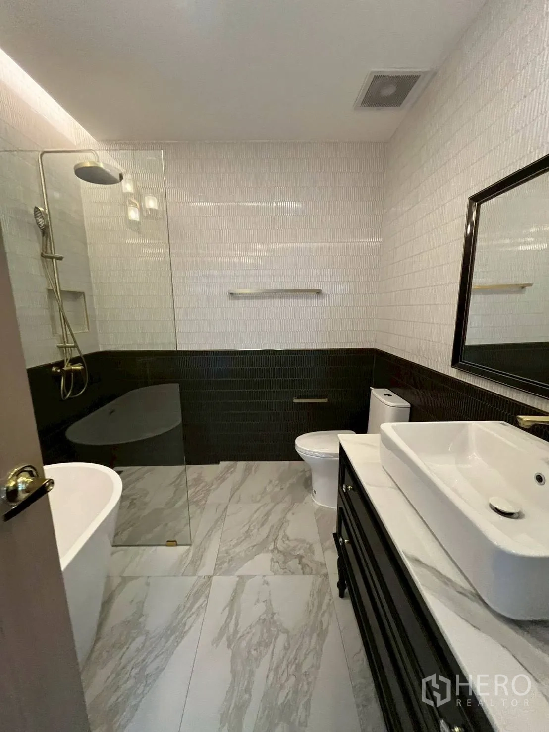 Townhouse for rent in Khlong Toei, Bangkok - Full bathroom with freestanding bathtub, rain shower, and two-tone tiles.