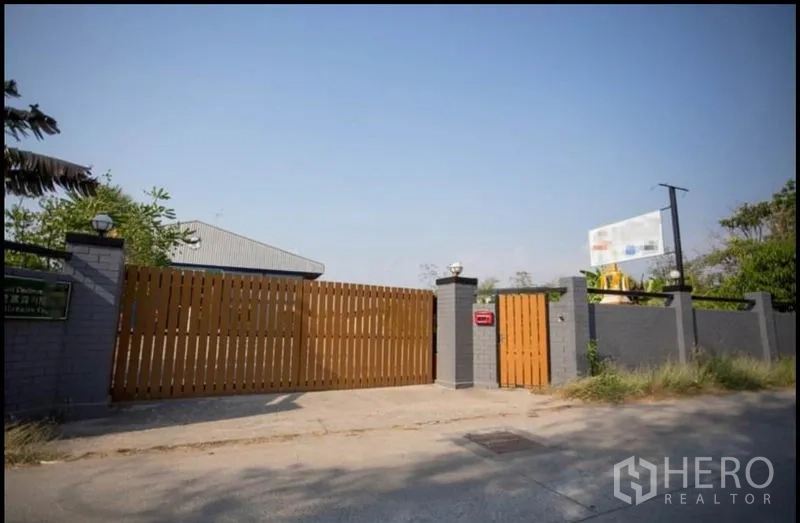 โรงงาน ขายในChon Buri - ประตูทางเข้าแบบสไลด์ไม้และกำแพงรอบโครงการอย่างปลอดภัย