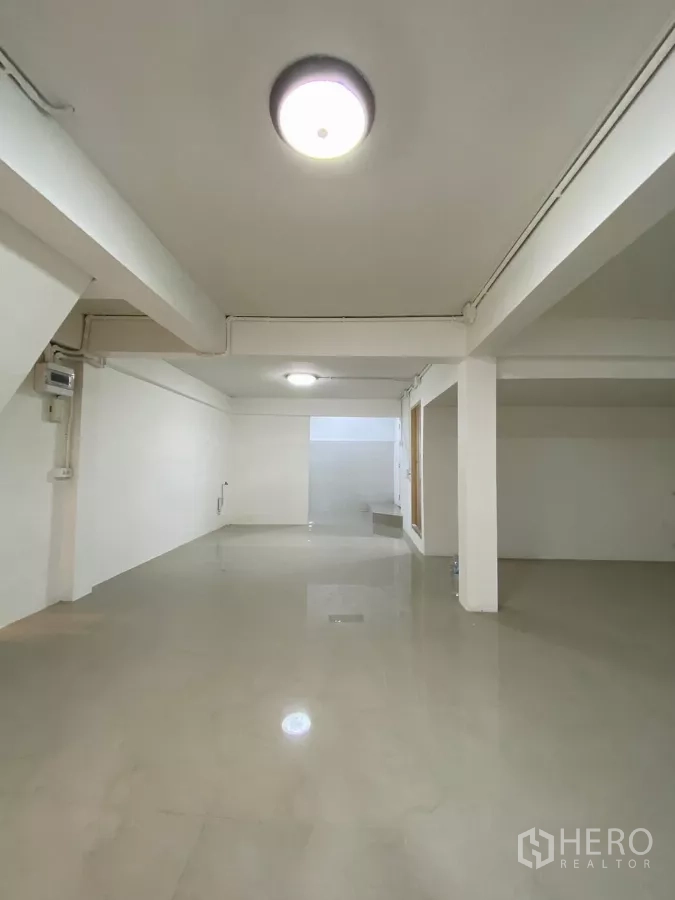 独立式住宅 出租在Bang Na, Bangkok - 深进的开放空间，光亮地砖与顶灯，通向房屋后部。