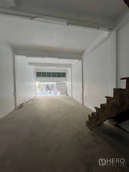 Shophouse for rent in Watthana, Bangkok - View from interior toward the street through a folding metal front gate.