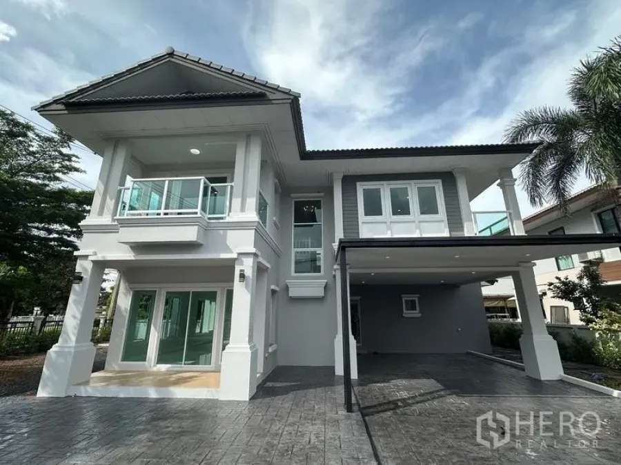 Detached House for sale in Lam Luk Ka, Pathum Thani - Front elevation highlighting classic pillars, glass railings and paved frontage.