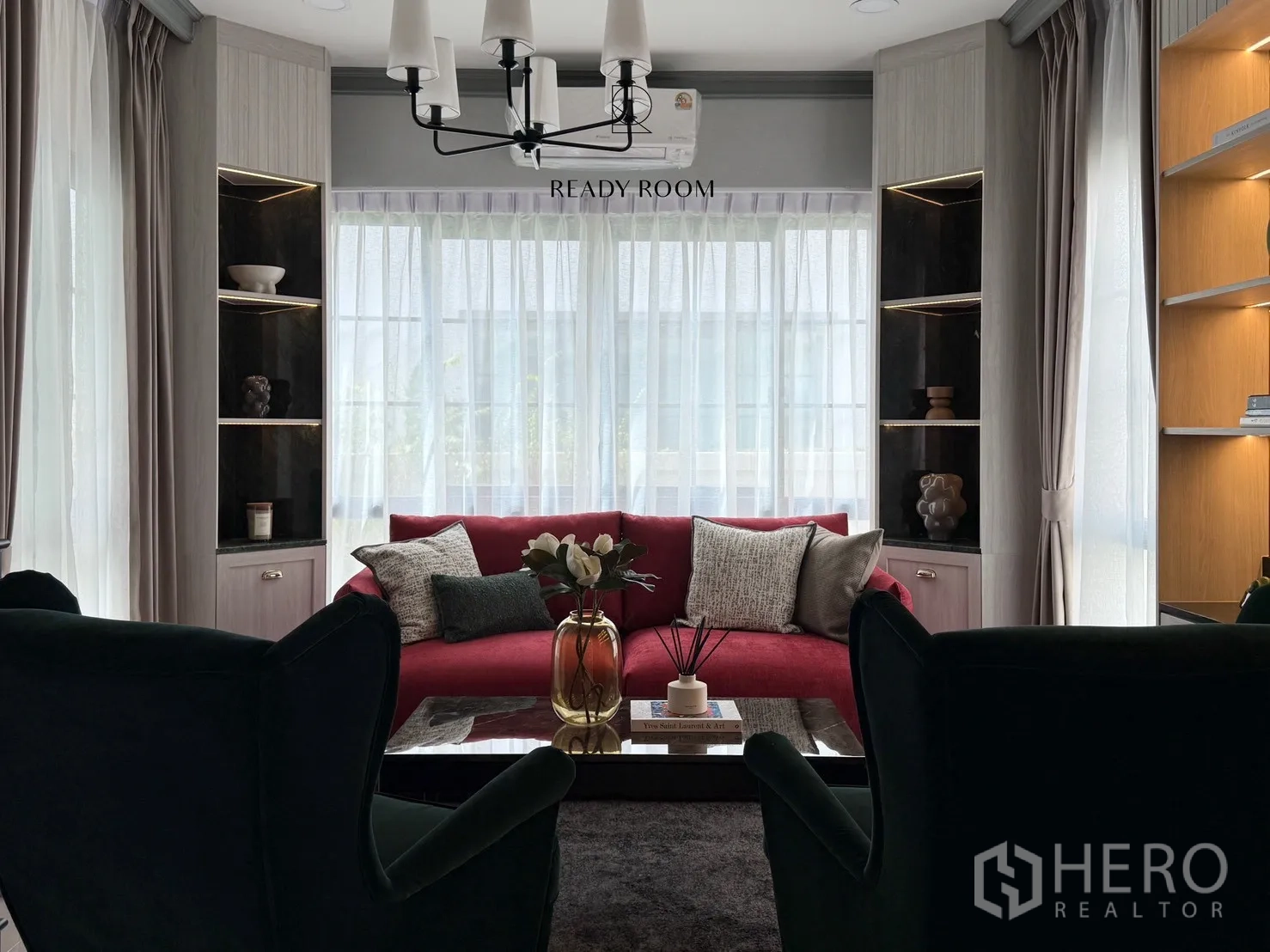 Detached House for rent or sale in Bang Phli, Samut Prakan - Family lounge featuring a red sofa, dark armchairs, built-in shelves and soft lighting.