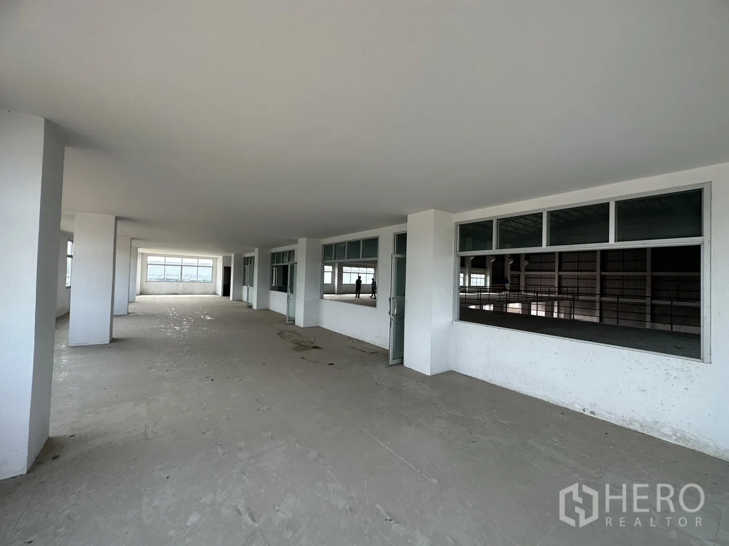Factory for rent in Pak Kret, Nonthaburi - Office wall with sliding window openings looking into the warehouse hall.