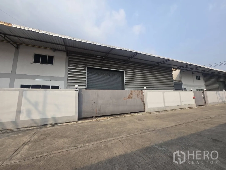 Factory for rent or sale in Mueang Samut Sakhon, Samut Sakhon - Row of factory buildings featuring metal cladding, roller doors, and perimeter walls.
