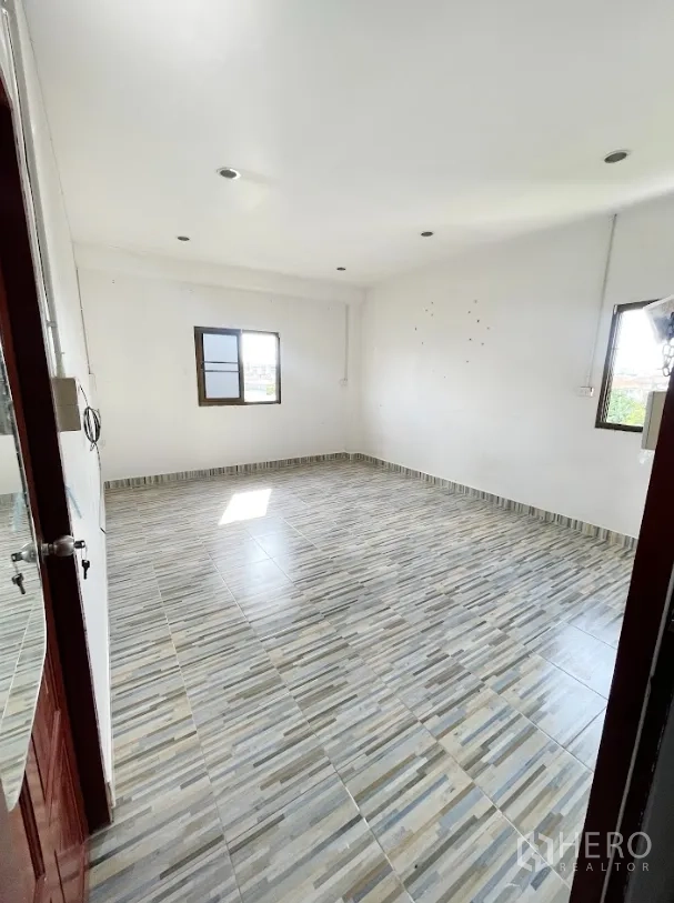 Warehouse for rent or sale in Thanyaburi, Pathum Thani - Bright tiled office room with windows on two sides.
