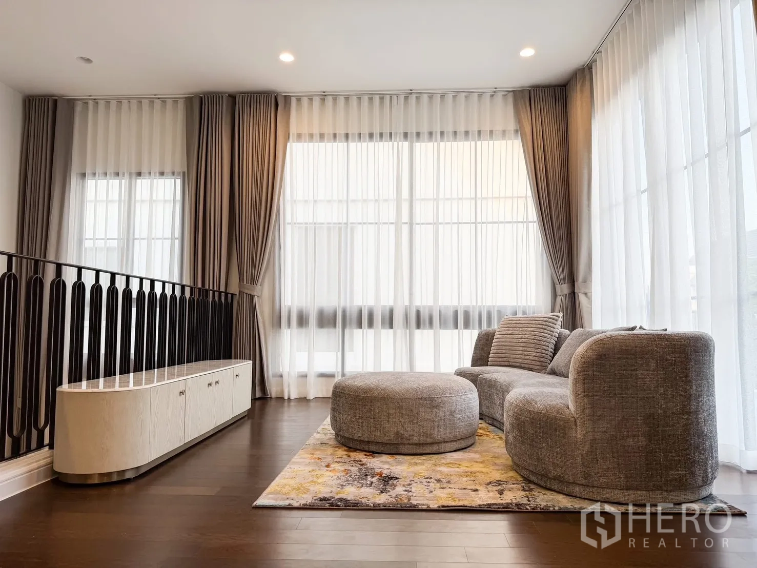 Detached House for rent in Bang Khen, Bangkok - Family area by staircase with console cabinet, large windows and plush seating.