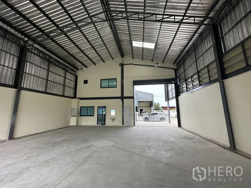 Factory for rent or sale in Bang Yai, Nonthaburi - Warehouse interior with 8-meter high steel roof, skylight and large roller door.
