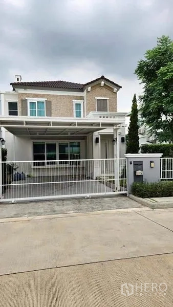 Detached House for rent - Two-storey detached house at Anya Bangna with gated entrance, covered carport and landscaped front yard.