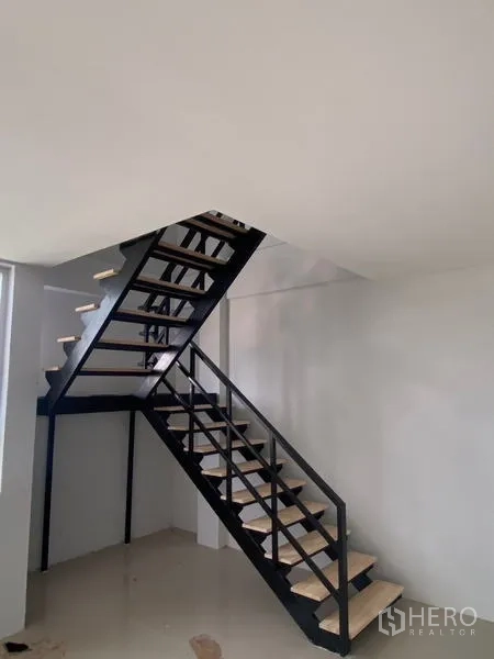 Warehouse for rent in Bang Phli, Samut Prakan - Black steel staircase leading to a mezzanine office inside the warehouse.