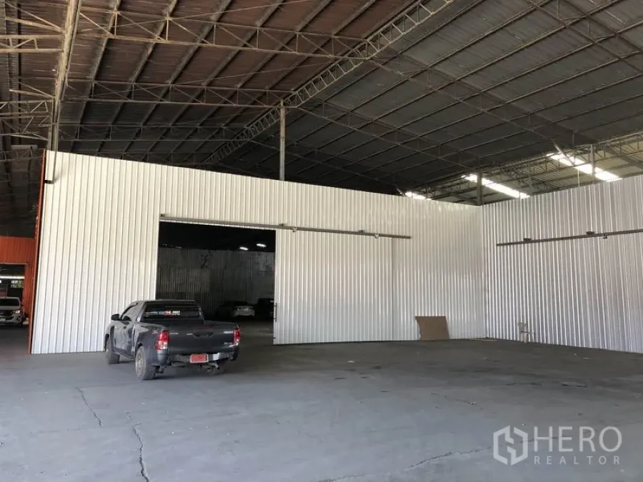 Warehouse for rent in Nong Chok, Bangkok - Large indoor loading bay in a high-roof warehouse featuring sliding metal doors and open clear-span space.