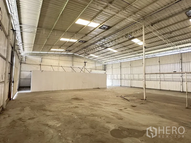 Warehouse for rent in Min Buri, Bangkok - Spacious warehouse bay with metal roof, ventilation panels, and drive-in loading access.