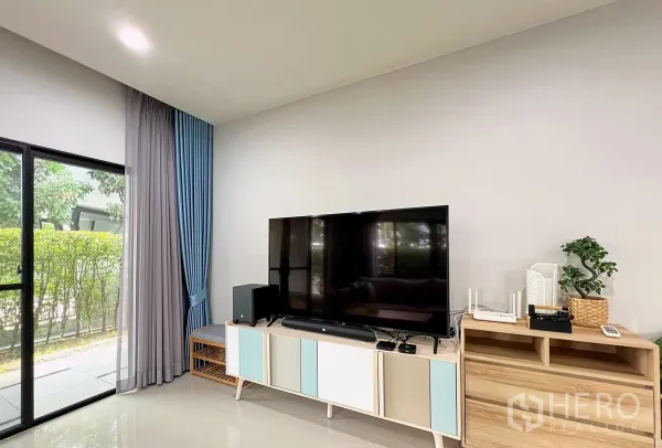 Detached House for rent or sale in Lam Luk Ka, Pathum Thani - Media wall with large flat-screen TV, console and sliding door to patio.