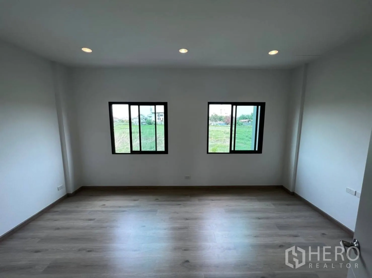Townhouse for rent in Bang Khen, Bangkok - View from stair landing into a bright bedroom with double windows.